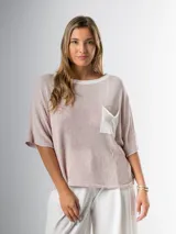 Remera tejida en hilo italiano, color beige, con cuello a la base y bolsillo frontal. De caída relajada y silueta amplia.