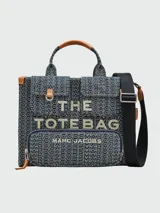 Bolso tote mediano de denim con monograma de la marca Marc Jacobs, con doble asa de mano de cuero y correa bandolera ajustable de tela.