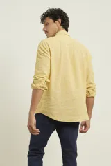 Camisa azul marino de lino y algodón, con cuello abotonado, manga larga con puños enrollados, bolsillo de parche en el pecho y cierre frontal con botones.