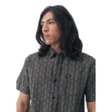 Camisa de manga corta con estampado de rayas verticales color gris y ocre. Tiene cuello clásico, cierre con botones y bolsillo en el pecho con logo de la marca. Corte recto.