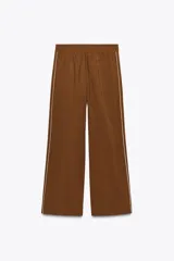 Pantalón marrón de tiro alto con cintura elástica, bolsillos delanteros y detalle de banda lateral blanca a contraste.