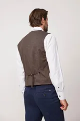 Chaleco de corte clásico color marrón, con botones y bolsillos frontales, ideal para looks formales.