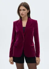 Blazer de terciopelo color borgoña, con solapas de muesca, cierre de un botón y bolsillos delanteros con solapa.