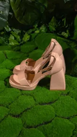 Sandalias negras de cuero sintético, con plataforma y taco cuadrado. Tiras anchas sobre el empeine y pulsera al tobillo con hebilla metálica.