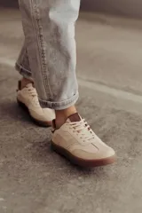 Zapatillas bajas de cuero color marrón con suela de goma color caramelo y cordones marrones.