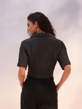 Camisa color verde lima con textura arrugada, corte holgado, mangas cortas y lazo para atar en la parte delantera.