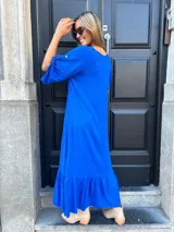 Vestido largo azul eléctrico con escote en V, mangas cortas con detalle de lazo y falda con volantes.