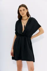 Vestido corto negro de poliéster, con escote cruzado, mangas cortas y cintura elastizada.