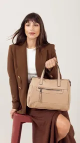 Cartera color beige con correa corta, cierre principal, bolsillos interiores y exteriores en la parte delantera y trasera. Incluye correa larga ajustable para mayor comodidad y versatilidad en el uso diario.