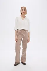 Pantalón de algodón color beige, de corte recto y tiro medio, con bolsillos laterales y cintura con cordón ajustable.