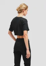 Remera negra cropped de algodón con cuello redondo y mangas cortas. Estampado frontal con alas y texto 'Los Angeles'.