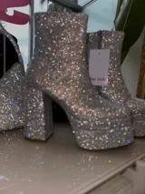 Botas cortas con plataforma y taco ancho, cubiertas de strass y cierre lateral.