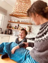 Sweater de punto color gris con guarda pampa en blanco y negro en la parte superior.