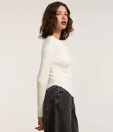Blusa de rib color blanco, con cuello redondo, mangas largas y bajo redondeado.