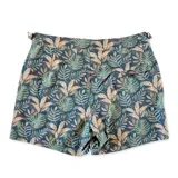 Short de baño con estampado de hojas de palmera en tonos verde, marrón y azul sobre fondo azul oscuro. Tiene pretina fija con hebillas metálicas laterales para ajustar, botón a presión y cierre frontal. Incluye tres bolsillos (dos laterales y uno trasero).
