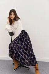 Falda larga de viscosa jacquard con lurex dorado, estampado geométrico, tajo central, ruedo irregular y cintura elastizada.