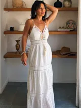 Vestido largo blanco de algodón bordado, con breteles finos, escote en V y falda con volantes.