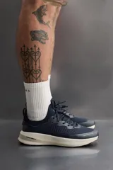 Zapatilla deportiva azul marino con capellada de tejido de punto transpirable, ajuste con cordones, plantilla OrthoLite® extraíble y suela con tecnología Spume Foam V2.