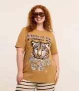 Remera alargada de algodón color ocre, con cuello redondo y mangas cortas. Presenta un estampado de la cara de un leopardo rodeada de flores y la frase "Starlit Sky".
