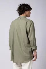 Camisa color arena de lino, manga larga, con cuello clásico y corte holgado.