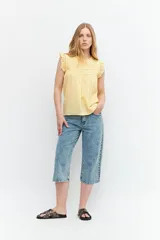 Musculosa amarilla sin mangas con alforzas en la parte delantera, diseño ligero y fresco.