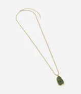 Collar largo con cadena dorada de eslabones tipo serpiente y colgante de resina verde con forma irregular y detalles de piedra astillada.