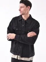 Campera de jean negra con botones metálicos, bolsillos frontales con solapa y cuello clásico.