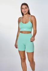 Conjunto deportivo color verde menta, compuesto por un top con breteles finos y logo 'bk.' estampado en el frente, y un short de ciclista de tiro alto.
