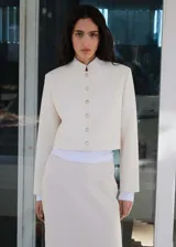 Chaqueta corta color crema con cuello mao y cierre frontal con botones joya.