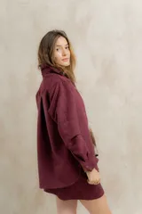 Minifalda color borgoña confeccionada en gamuza sintética con bordado de flechas en la parte delantera.