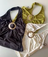 Top de lycra con cuello halter y hebilla metálica circular en el centro.