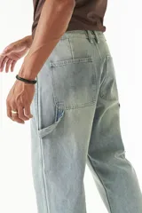 Pantalón jean celeste de corte amplio, estilo carpenter, con bolsillos laterales y logo bordado.