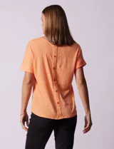 Remera color durazno con textura y espalda con aplique de botones.