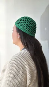 Gorro de crochet verde con diseño de red.