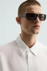 Camisa de manga larga color celeste claro, con cuello solapa y cierre frontal de botonadura. Presenta una textura sutil en el tejido.