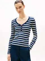 Remera de manga larga a rayas horizontales blancas y azules, con cuello Henley y botones dorados.