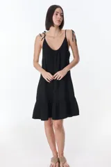 Vestido corto celeste con breteles finos y volados en el ruedo.