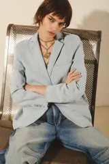 Blazer celeste de denim con costuras a contratono, forrería combinada en cuerpo y mangas, botones a tono personalizados y tela elastizada.