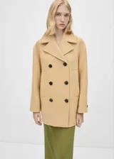 Abrigo corto color beige, de doble botonadura, con cuello con solapa y bolsillos laterales.