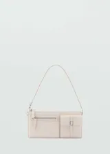 Bolso tipo baguette color crudo, con asa corta y cierre de cremallera. Tiene forro interior y bolsillos decorativos en la parte delantera.