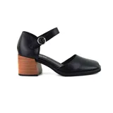 Sandalia de cuero sintético negro con pulsera al tobillo y hebilla plateada. Tiene taco de madera de 6 cm y punta cuadrada.
