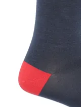 Calcetines largos de color gris oscuro con puntera y talón en color rojo.