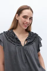 Blusa blanca de lyocell y algodón, con escote fruncido con volados y lazos.