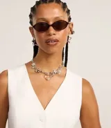 Chaleco de vestir color blanco hueso, con escote en V, cierre frontal con botones y espalda abierta. Corte sastrero.