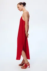 Vestido tobillero rojo de muselina de algodón suave, corte holgado con breteles finos ajustables, escote recto, espalda escotada y bajo recto con abertura pronunciada en los laterales.