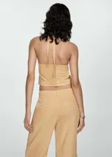Top color arena con escote halter y lazos ajustables en el frente.