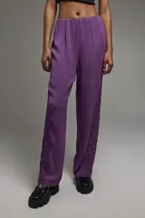 Pantalón de corte recto confeccionado en crepe fino, con elástico en cintura, cierre invisible y detalles de encaje en los laterales.