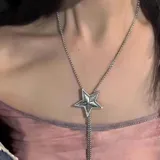 Collar plateado con dije en forma de estrella y cadena doble colgante.