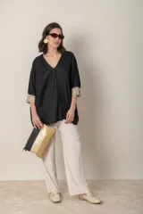 Blusa italiana color crema, tipo poncho, con escote en V con lurex, mangas 3/4 y puños ajustados.
