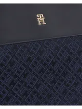 Bolso tipo tote de poliéster reciclado con diseño jacquard con monograma TH en azul marino. Tiene dos asas superiores de cuero sintético negro y logo metálico dorado de Tommy Hilfiger en el frente.